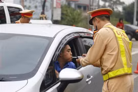 Cảnh sát giao thông huyện Sơn Dương kiểm tra nồng độ cồn của lái xe. (Ảnh: Nam Sương/TTXVN)