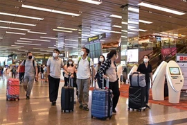 Khách du lịch đeo khẩu trang để phòng tránh lây nhiễm virus corona tại sân bay quốc tế Changi, Singapore. (Ảnh: AFP/TTXVN)