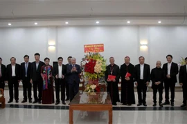 Bí thư Trung ương Đảng, Chủ tịch Ủy ban Trung ương Mặt trận Tổ quốc Việt Nam Đỗ Văn Chiến tặng lẵng hoa chúc mừng Giám mục chính tòa Giáo phận Vinh Anphong Nguyễn Hữu Long. (Ảnh: Văn Tý/TTXVN)