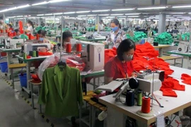 Công nhân Nhà máy may xuất khẩu Sơn Hà (thị xã Bỉm Sơn) bị giảm thu nhập do công ty thiếu đơn hàng. (Ảnh: Nguyễn Nam/TTXVN)