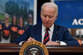 Tổng thống Mỹ Joe Biden ký một đạo luật tại Nhà Trắng ở Washington, DC. (Ảnh: AFP/TTXVN)