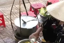 Bà H.T.T đổ nước thừa của khách vào bình. (Ảnh cắt từ clip)