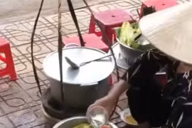 Bà H.T.T đổ nước thừa của khách vào bình. (Ảnh cắt từ clip)