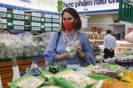 Đại sứ New Zealand tại Việt Nam Tredene Dobson mua rau an toàn tại siêu thị Co.op Mark Quy Nhơn do nông dân Bình Định sản xuất từ dự án Rau an toàn Bình Định. (Ảnh: Kha Phạm/TTXVN)