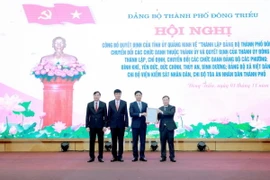 Phó Bí thư Tỉnh ủy, Trưởng Đoàn đại biểu Quốc hội Quảng Ninh Đặng Xuân Phương (phải) trao quyết định thành lập Đảng bộ thành phố Đông Triều. (Ảnh: Thanh Vân/TTXVN)