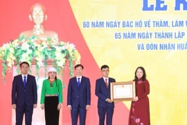 Phó Chủ tịch Võ Thị Ánh Xuân trao Huân chương Lao động hạng Ba của Chủ Tịch nước cho cán bộ và nhân dân huyện Kim Bôi. (Ảnh: Trọng Đạt/TTXVN)