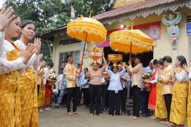 Đồng bào phật tử Khmer tiến hành nghi thức dâng y. (Ảnh: Nguyễn Hằng/TTXVN)