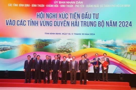 Lãnh đạo Ủy ban Nhân dân tỉnh Bình Định trao tặng quyết định chủ trương, giấy chứng nhận đầu tư cho các doanh nghiệp. (Ảnh: Sỹ Thắng/TTXVN)