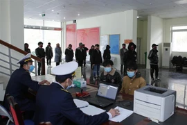 Lực lượng chức năng kiểm tra y tế, đo thân nhiệt và lập biên bản các trường hợp vượt biên trái phép về Việt Nam tại cửa khẩu Ma Lù Thàng, huyện Phong Thổ, tỉnh Lai Châu. (Ảnh: Quý Trung/TTXVN)