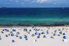Người dân tắm biển tại thành phố Miami, bang Florida, Mỹ. (Ảnh: AFP/TTXVN)