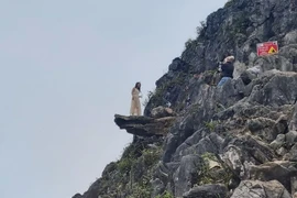 Du khách mạo hiểm chụp ảnh ở mỏm đá tử thần. Ảnh minh họa. (Ảnh: Nguyễn Chiến/TTXVN)