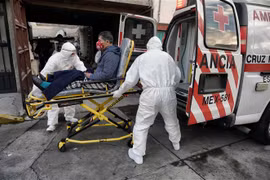 Nhân viên y tế chuyển bệnh nhân nhiễm COVID-19 lên xe cứu thương tại Toluca, Mexico. (Ảnh: AFP/TTXVN)