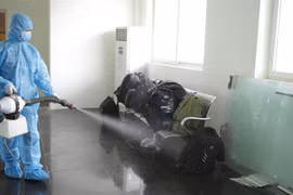 Các lực lượng chức năng phun khử khuẩn hành lý của các trường hợp vượt biên trái phép vào Việt Nam. (Ảnh: Quý Trung/TTXVN)