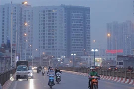 Người dân phải di chuyển trong tình trạng ô nhiễm không khí. (Ảnh: Hoàng Hiếu/TTXVN)