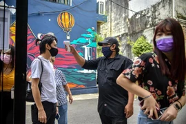 Kiểm tra thân nhiệt phòng lây nhiễm COVID-19 tại Kuala Lumpur, Malaysia. (Ảnh: THX/TTXVN)