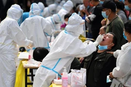 Nhân viên y tế lấy mẫu xét nghiệm COVID-19 cho người dân tại tỉnh Sơn Đông, Trung Quốc. (Ảnh: AFP/TTXVN)
