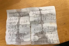 Mẩu giấy viết tay kêu cứu của các thợ mỏ bị mắc kẹt trong vụ sập mỏ vàng ở tỉnh Sơn Đông (Trung Quốc) được chuyển lên mặt đất qua đường ống khoan. (Ảnh: THX/TTXVN)