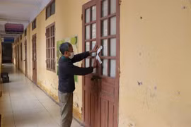 Tiến hành dán niêm phong phòng học. (Ảnh: Mạnh Minh/TTXVN)