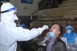 Lấy mẫu xét nghiệm cho người dân về từ vùng dịch tại Trường THPT Phan Huy Chú (quận Đống Đa) chiều 31/1. (Ảnh: Hoàng Hiếu/TTXVN)