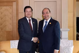 Thủ tướng Nguyễn Xuân Phúc gặp Thủ tướng Lào Thongloun Sisoulith tại Busan, Hàn Quốc. (Ảnh: Thống Nhất/TTXVN)