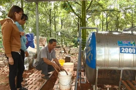 Ông Đỗ Lương Ý hướng dẫn người dân xã Nhân Nghĩa, huyện Cẩm Mỹ, tỉnh Đồng Nai sử dụng hệ thống tưới 3 trong 1. (Ảnh: Lê Xuân/TTXVN)