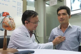 Tiến sỹ, bác sỹ Nguyễn Thái An, Trưởng Khoa Hồi sức phẫu thuật tim - Bệnh viện Chợ Rẫy tái khám cho bệnh nhân sau khi áp dung phương pháp phẫu thuật tim mới. (Ảnh: Đinh Hằng/TTXVN)