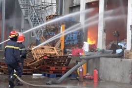 Lực lượng phóng cháy, chữa cháy nỗ lực dập lửa. (Ảnh: Nguyễn Văn Việt/TTXVN)