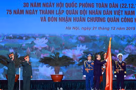 Thủ tướng Nguyễn Xuân Phúc, Chủ tịch Hội đồng thi đua - khen thưởng Trung ương trao tặng Huân chương Quân công hạng Nhất cho Bộ Quốc phòng. (Ảnh: Thống Nhất/TTXVN)