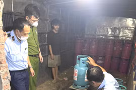 Lực lượng chức năng tiến hành kiểm tra hàng hóa có dấu hiệu vi phạm về kinh doanh khí hóa lỏng. (Ảnh: PV/Vietnam+)