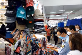 Lực lượng Quản lý thị trường kiểm tra hàng hóa tại một kiốt của Trung tâm mua sắm Sài Gòn Square. (Ảnh: PV/Vietnam+)