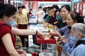 Khách hàng giao dịch vàng miếng. (Ảnh: Đức Duy/Vietnam+)