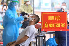 Nhân viên y tế lấy mẫu xét nghiệm sàng lọc SARS-CoV-2 cho người dân. (Ảnh: Hoàng Hiếu/TTXVN)