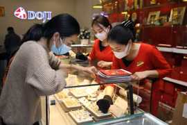 Khách hàng đang giao dịch vàng miếng. (Ảnh: TTXVN)