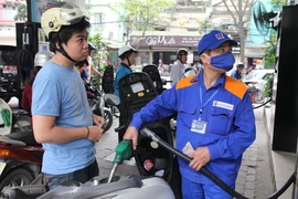 Nhân viên Petrolimex đang bán xăng cho khách hàng. (Ảnh: Đức Duy/Vietnam+)