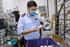 Lực lượng Quản lý thị trường Hà Nội kiểm tra cơ sở gia công, lắp ráp sạc điện thoại, ipad giả mạo nhãn hiệu. (Ảnh: PV/Vietnam+)
