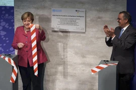 Tổng Giám đốc WHO Tedros Adhanom Ghebreyesus (phải) và Thủ tướng Đức Angela Merkel cắt băng khai trương Trung tâm Cảnh báo sớm đại dịch tại thủ đô Berlin (Đức), ngày 1/9/2021. (Ảnh: AFP/TTXVN)
