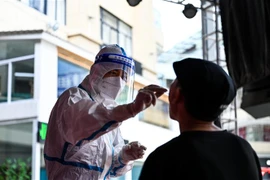 Nhân viên y tế lấy mẫu xét nghiệm COVID-19 ở thành phố Thụy Lệ, tỉnh Vân Nam (Trung Quốc), ngày 5/7/2021. (Ảnh: THX/TTXVN)