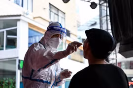 Nhân viên y tế lấy mẫu xét nghiệm COVID-19 ở thành phố Thụy Lệ, tỉnh Vân Nam (Trung Quốc), ngày 5/7/2021. (Ảnh: THX/TTXVN)