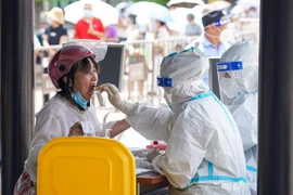 Nhân viên y tế lấy mẫu xét nghiệm COVID-19 cho người dân tại Dương Châu, tỉnh Giang Tô (Trung Quốc), ngày 7/8/2021. (Ảnh: THX/TTXVN)