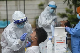 Nhân viên y tế lấy mẫu xét nghiệm COVID-19 tại Jakarta. (Ảnh: AFP/TTXVN)