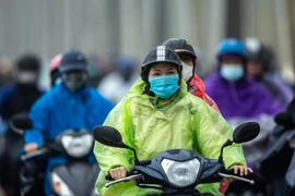 Người dân Hà Nội đi làm trong mưa rét. (Ảnh: Minh Sơn/Vietnam+)