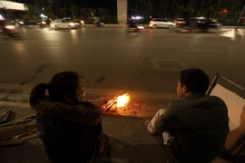 Người dân Hà Nội đốt lửa sưởi ấm. (Ảnh: TTXVN)