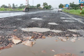 Mặt đường Quốc lộ 1A hư hỏng nặng. (Ảnh: Phạm Cường/TTXVN)