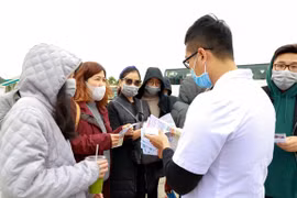 Cán bộ nhân viên Trung tâm Kiểm soát bệnh tật truyền thông trực tiếp về nCov đến khách du lịch. (Ảnh: TTXVN phát) 