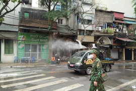 Phun thuốc khử trùng khu vực phố Trúc Bạch sáng 7/3. (Ảnh: Sơn Bách/Vietnam+) 