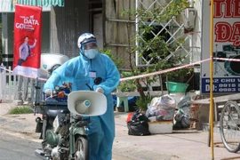 Lực lượng chức năng thị trấn Phú Mỹ, huyện Phú Tân tăng cường công tác tuyên truyền lưu động đến tận sâu trong các khu phong tỏa nhằm nhắc nhỏ, nâng cao ý thức phòng, chống dịch của người. (Ảnh: Công Mạo/TTXVN)