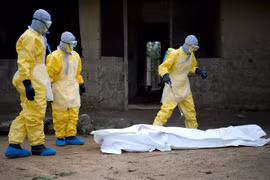 Nhân viên Chữ thập Đỏ Guinea chuyển thi thể bệnh nhân tử vong do virus Ebola tại bệnh viện ở Conakry, ngày 19/11/2014. (Ảnh: AFP/TTXVN)