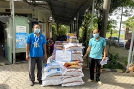 Đại diện Công đoàn các Khu chế xuất, Khu công nghiệp thành phố tặng lương thực, thực phẩm và đồ dùng thiết yếu cho công nhân lao động ở khu lưu trú Hiệp Phước, huyện Nhà Bè. (Ảnh: Thanh Vũ/TTXVN)