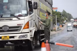 Lực lượng chức năng tại chốt kiểm soát đầu cầu Trung Hà (huyện Ba Vì, Hà Nội) kiểm tra giấy tờ của người và phương tiện khi qua chốt. (Ảnh: Minh Quyết/TTXVN)