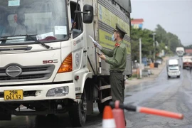Lực lượng chức năng tại chốt kiểm soát đầu cầu Trung Hà (huyện Ba Vì, Hà Nội) kiểm tra giấy tờ của người và phương tiện khi qua chốt. (Ảnh: Minh Quyết/TTXVN)
